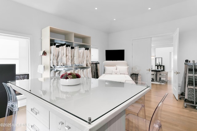 kitchen with white cabinets, a center island, light hardwood / wood-style flooring, and a breakfast bar area