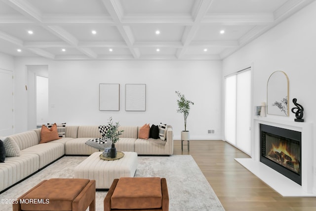 living room featuring beamed ceiling, coffered ceiling, and light hardwood / wood-style flooring