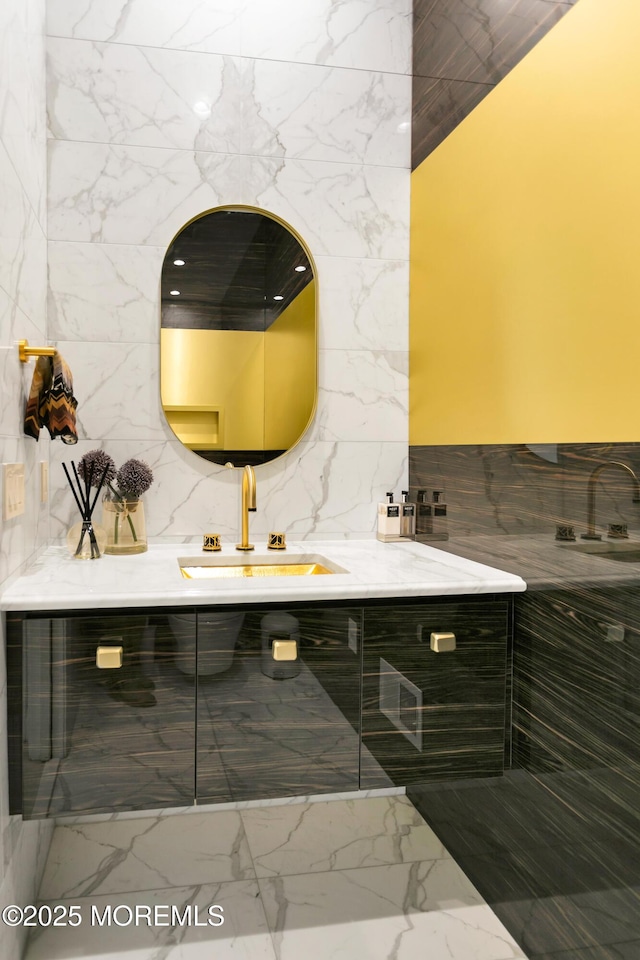 bathroom featuring vanity and tile walls