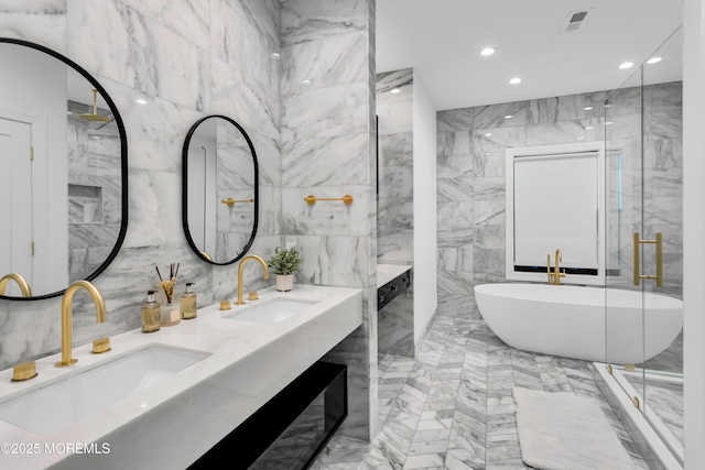 bathroom with a washtub, vanity, and tile walls