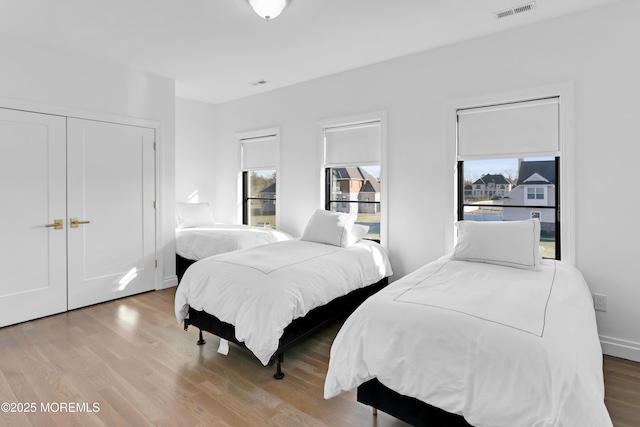 bedroom with light wood-type flooring and multiple windows