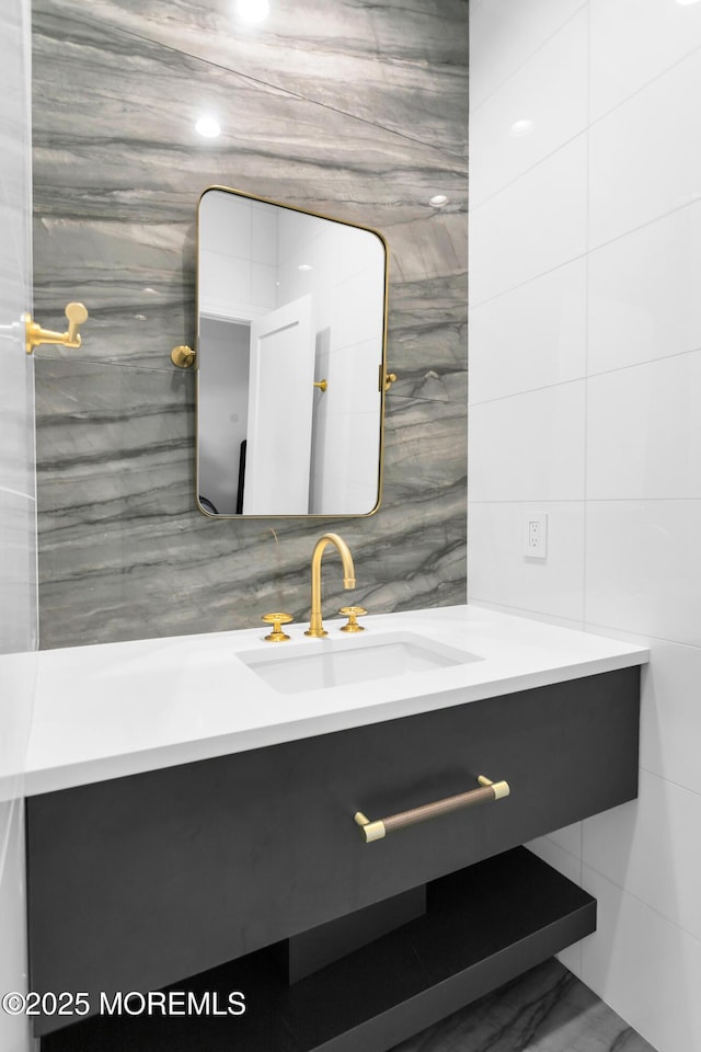 bathroom featuring vanity and tile walls