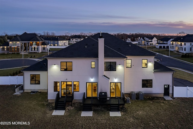 back house at dusk featuring a yard