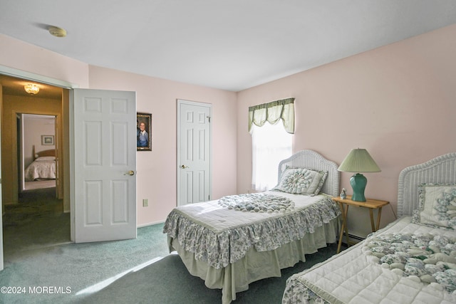 carpeted bedroom featuring a baseboard heating unit