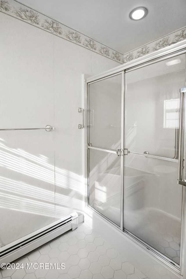 bathroom with baseboard heating, tile patterned floors, and a shower with shower door