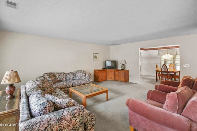 living room with light carpet, a notable chandelier, and a textured ceiling