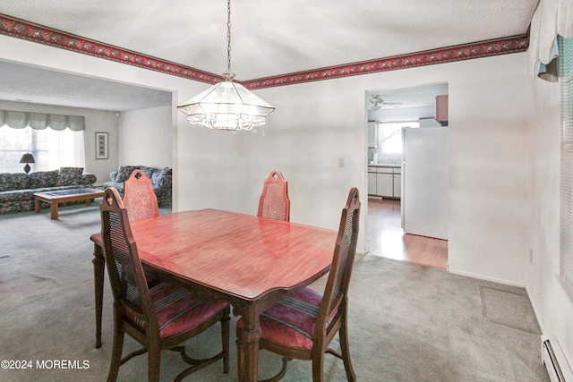 carpeted dining room featuring a textured ceiling, a baseboard heating unit, and ceiling fan with notable chandelier