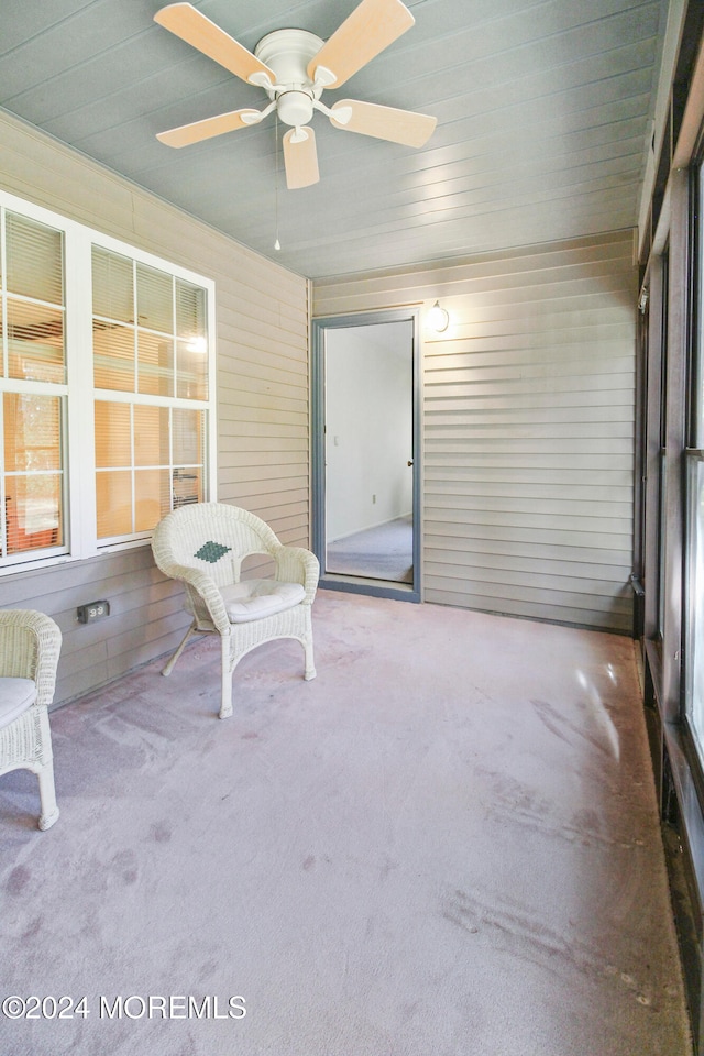 unfurnished sunroom featuring wooden ceiling and ceiling fan