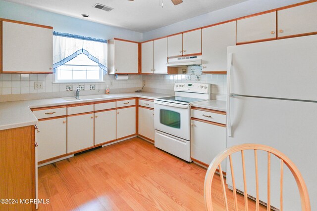 kitchen with sink, white cabinets, light hardwood / wood-style flooring, and white appliances