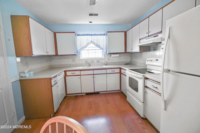 kitchen with white appliances, light hardwood / wood-style flooring, sink, and white cabinets