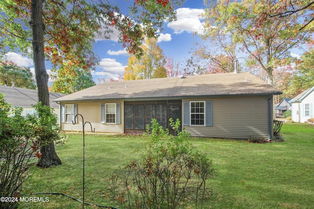 back of property featuring a sunroom and a lawn