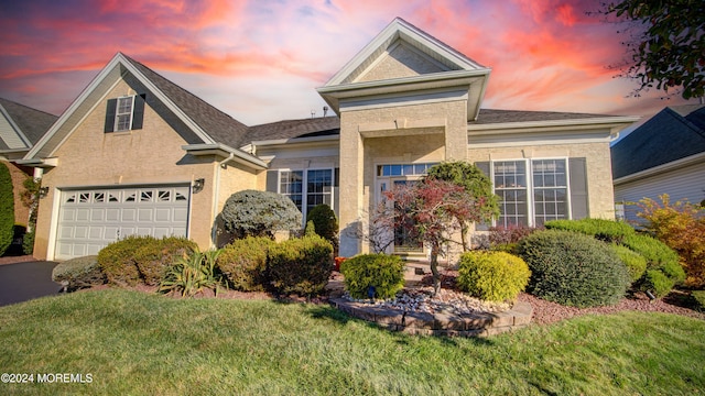 front facade with a garage and a lawn