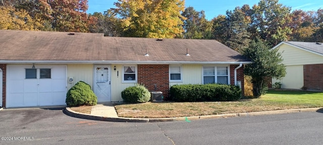 ranch-style home with a garage and a front lawn