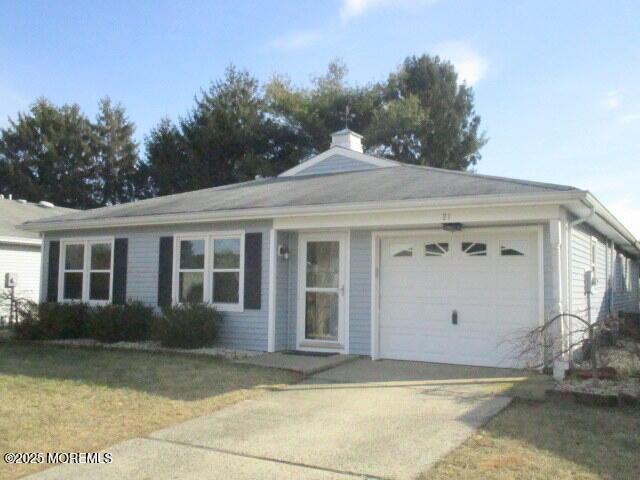 ranch-style home with a garage and a front lawn