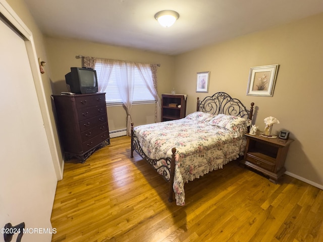 bedroom featuring hardwood / wood-style flooring and a baseboard radiator