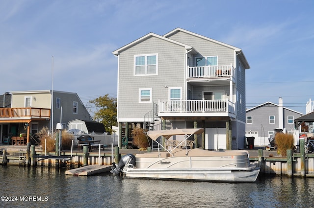 back of house featuring a water view and a balcony