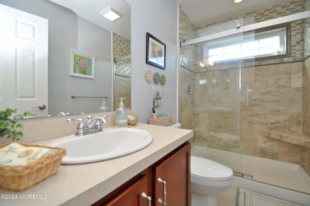 bathroom featuring vanity, toilet, and an enclosed shower