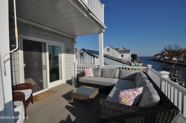 wooden deck with a water view and an outdoor hangout area