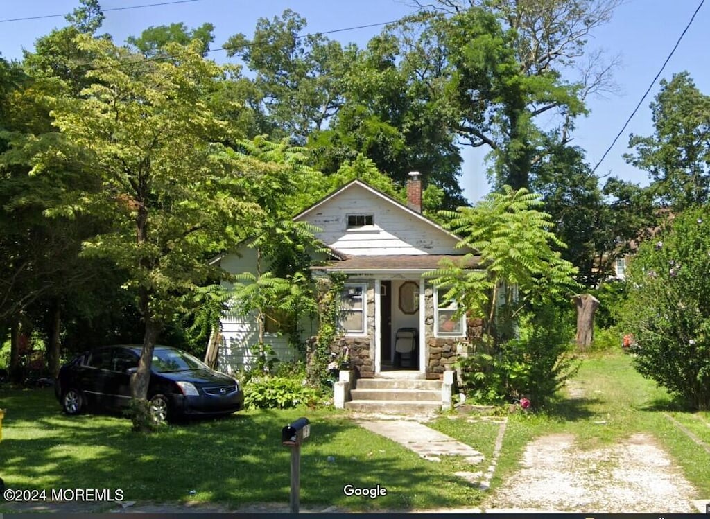 bungalow featuring a front lawn