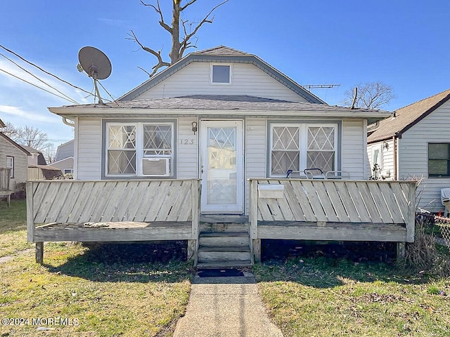 bungalow featuring a front lawn and a deck