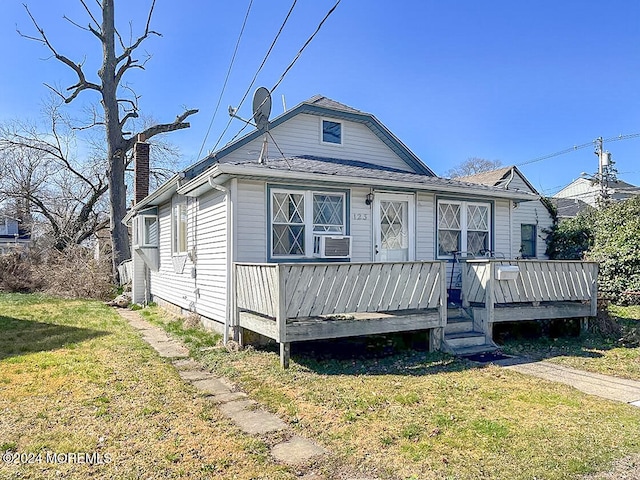 bungalow-style home with a front lawn and a deck