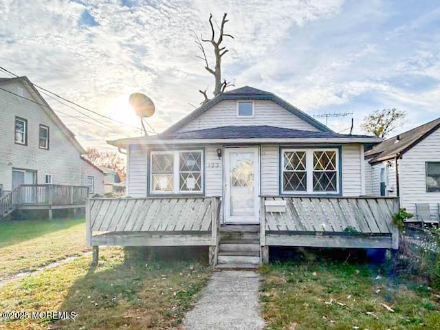 rear view of property featuring a lawn