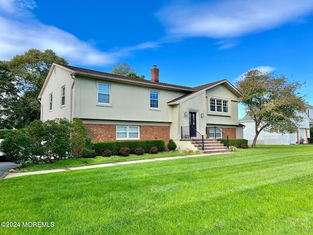 raised ranch featuring a front lawn