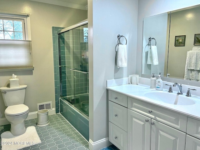 full bathroom featuring tile patterned floors, bath / shower combo with glass door, vanity, crown molding, and toilet