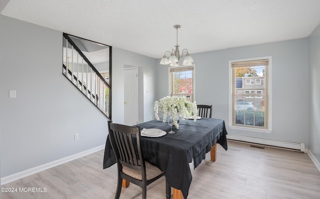 dining space with a notable chandelier, a textured ceiling, a baseboard radiator, and light wood-type flooring