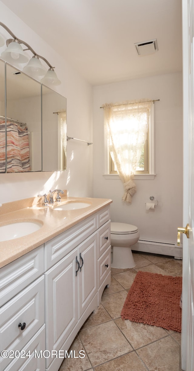 bathroom featuring toilet, vanity, and a baseboard radiator