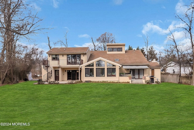 back of house featuring a hot tub and a yard