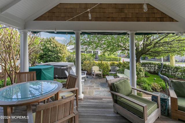 view of patio with a hot tub, a gazebo, and an outdoor living space