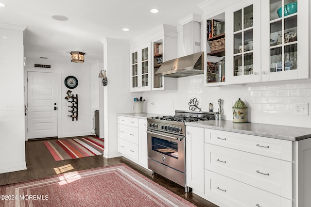 kitchen with wall chimney exhaust hood, stainless steel range, dark hardwood / wood-style floors, and white cabinets