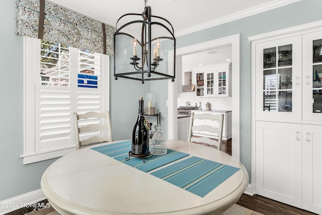 dining space with crown molding, hardwood / wood-style flooring, and an inviting chandelier