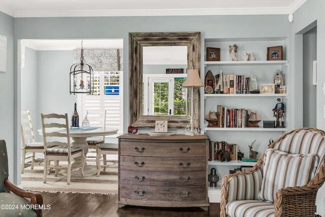 living area featuring crown molding, dark hardwood / wood-style floors, and a chandelier