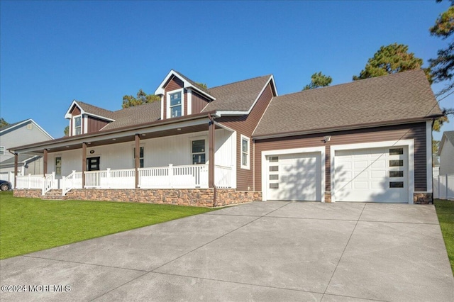 new england style home featuring a garage, a front yard, and a porch