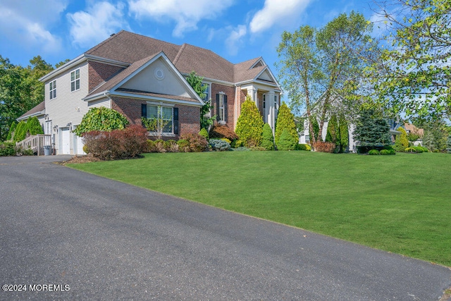 view of front of property featuring a front yard and a garage