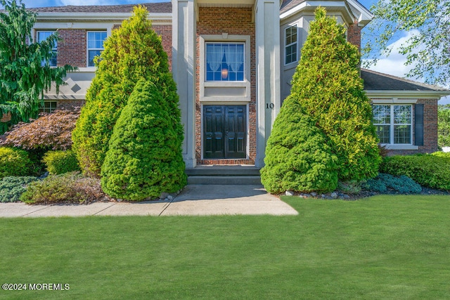 doorway to property featuring a lawn