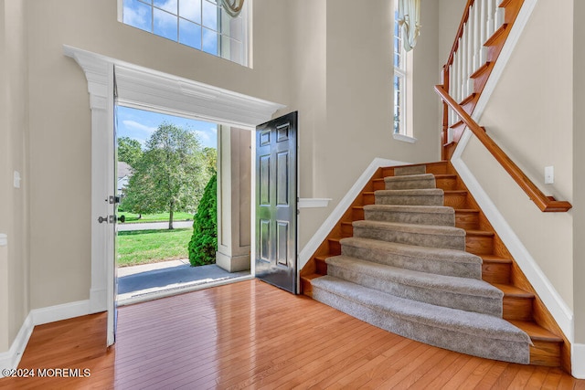 entrance foyer with a towering ceiling and hardwood / wood-style floors