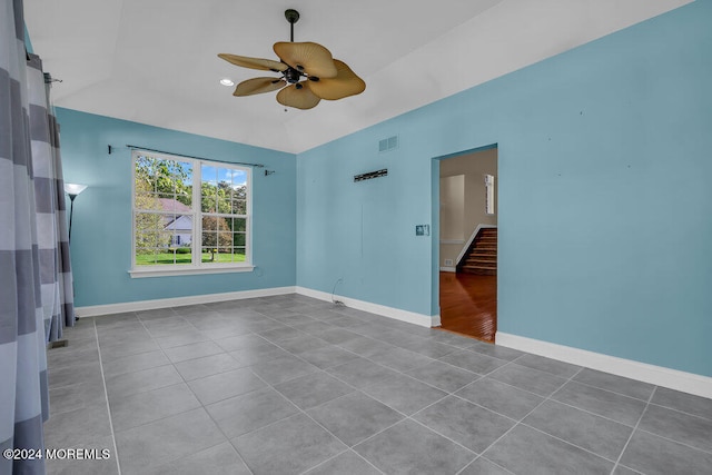 tiled empty room with vaulted ceiling and ceiling fan