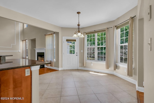 interior space featuring a wealth of natural light, a chandelier, and light tile patterned flooring