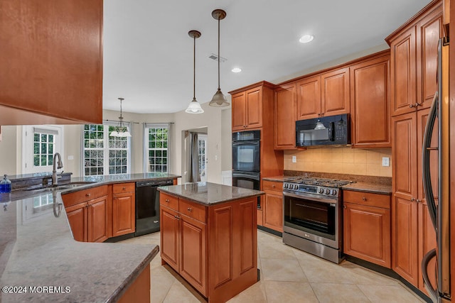 kitchen with sink, black appliances, hanging light fixtures, and dark stone countertops