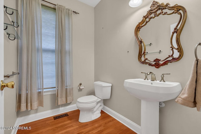 bathroom featuring toilet and wood-type flooring