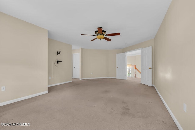 empty room featuring light colored carpet and ceiling fan