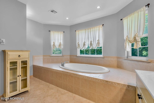 bathroom with vanity, tile patterned floors, tiled tub, and plenty of natural light