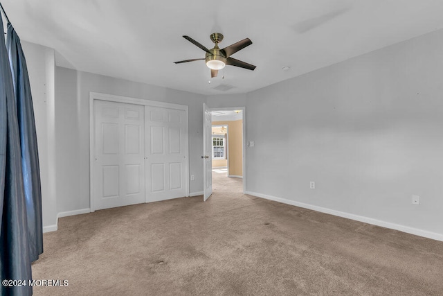 unfurnished bedroom featuring light colored carpet, a closet, and ceiling fan