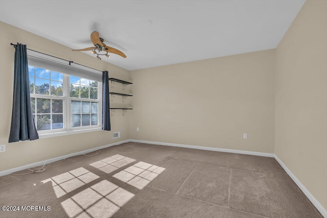 carpeted spare room featuring ceiling fan