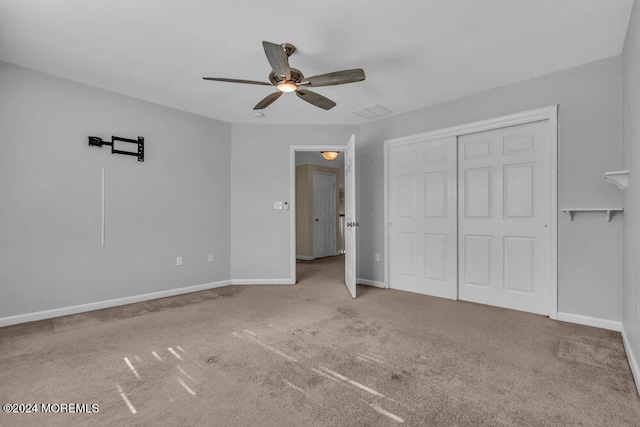 unfurnished bedroom featuring carpet flooring, a closet, and ceiling fan