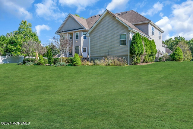 rear view of house featuring a lawn