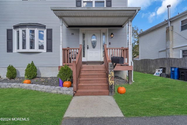 entrance to property featuring a yard and a porch